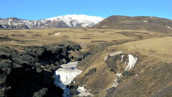 北极的自然瀑布和冰冰岛的冬天冰岛冬季景观高高的瀑布和岩石雪和冰是冰岛旅游的好去处