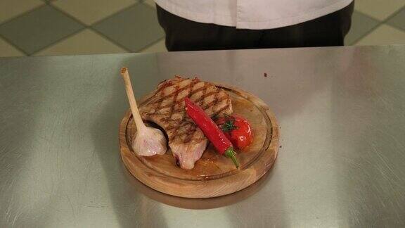 特写镜头厨师把炸好的肉放在盘子里撒上香料