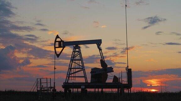 夕阳下无人居住的地区油泵工作的剪影石油钻机和泵千斤顶沙漠油田的石油钻井井架用于化石燃料的开采和原油的开采