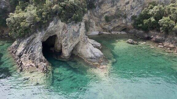鸟瞰图一个美丽的洞穴与绿松石海轨道移动