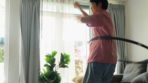 亚洲男孩在家靠窗玩呼啦圈积极的生活方式