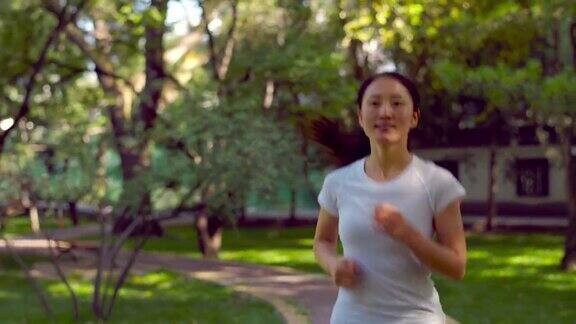 年轻的亚洲女性在城市公园跑步