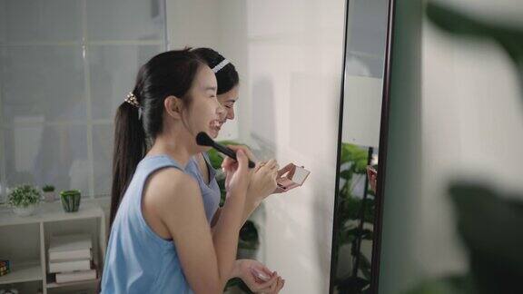 一个年轻漂亮的亚洲女人在镜子前化妆