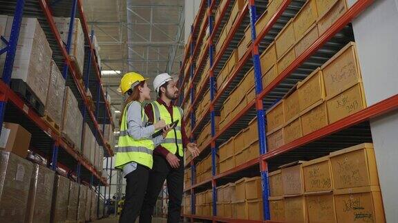 仓库内的亚洲职员正在检查货架上的箱子并整理箱子