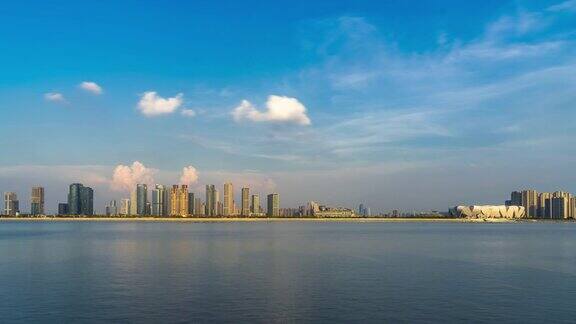 现代城市近河的城市景观在蓝天中时光流逝