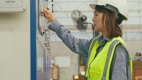 专业的亚洲女性工业工程师在制造工厂操作机器键盘在制造厂或生产厂工作