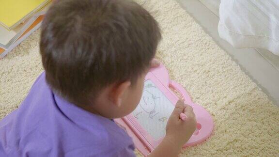 克里德小男孩在幼儿园的磁性画板上写字