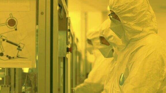 无菌高精密制造实验室科学家在防护服的制造药理电子计算机设备橙色的颜色