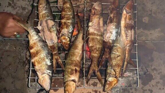用木炭在烤鱼架上烤腌制过的遮目鱼