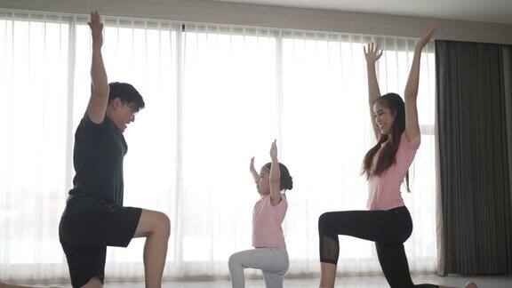 爸爸妈妈和他们的女儿在家里锻炼
