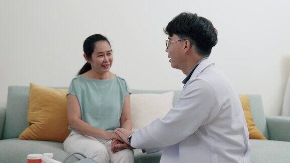 年轻的亚洲男性医生向病人保证她的健康状况正在改善
