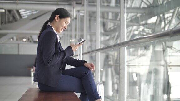 亚洲女商人在机场使用智能手机