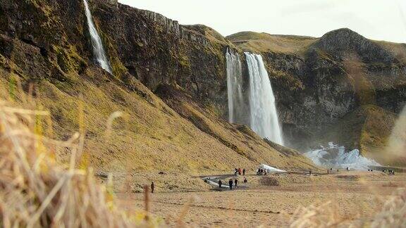 冰岛南部地区-2023年3月5日-游客在春天参观美丽的Seljalandsfoss瀑布
