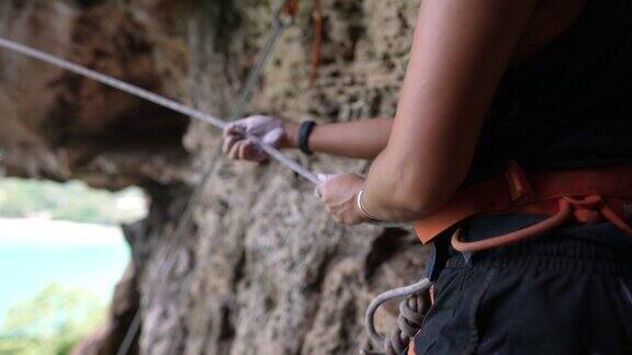4K信心亚洲女性登山者准备在夏天的热带岛屿上用安全绳索和挽具爬上岩石山健康强壮的女性喜欢积极的生活方式和假期极限运动