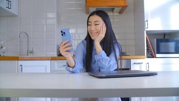 美丽年轻的亚洲妇女在视频电话交谈漂亮女孩使用现代智能手机进行在线交流来自越南的可爱女性使用手机社交媒体应用程序进行交流