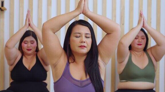 亚洲大码女人在健身房一起做瑜伽