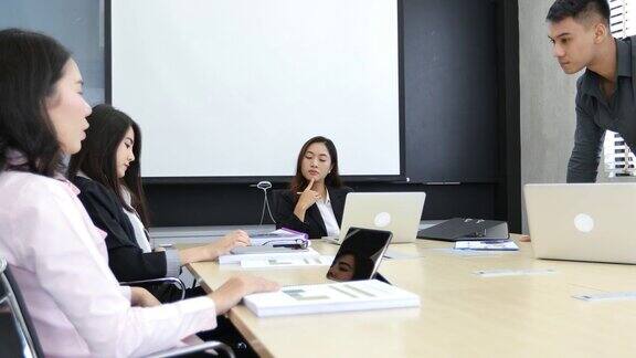 亚洲商业女性和团体在会议上用笔记本给商业伙伴讨论文件和想法商业女性在工作中微笑