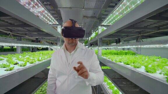 一位现代男性微生物学家使用虚拟现实眼镜来控制和管理现代有机蔬菜农场的气候