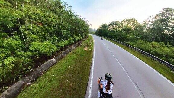 周末上午亚洲华人女自行车手在乡村风景中骑行