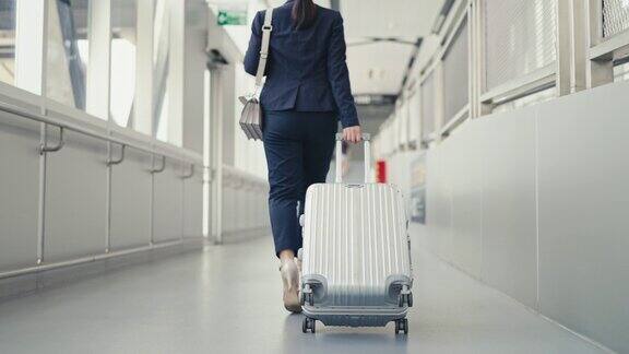 女商人提着行李箱在机场散步