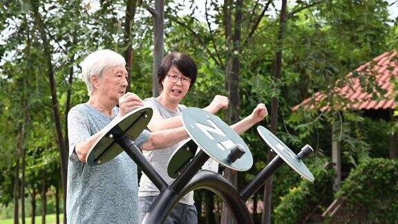活跃的亚裔老年妇女和她的女儿在社区公园锻炼