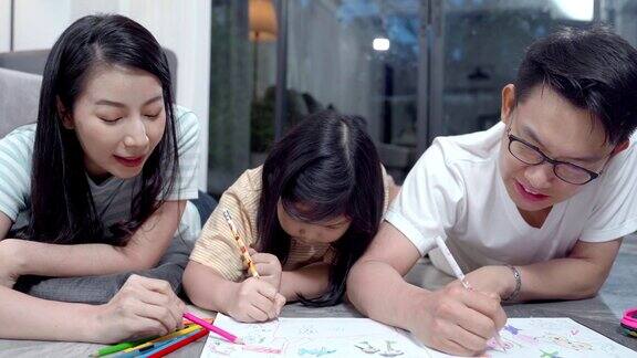 女儿和父母在家里的地板上画画幸福的亚洲家庭花时间在一起