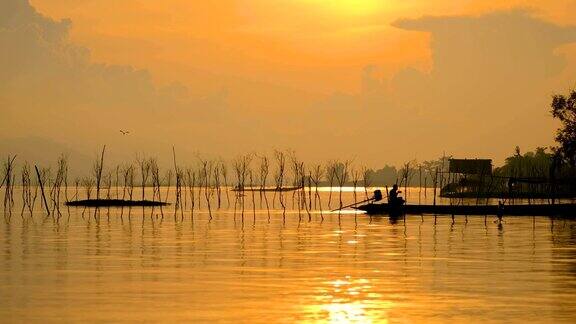 亚洲渔民在清晨金色的阳光下撒播着网鱼