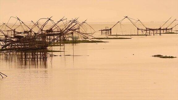 在Pakpra运河渔民们拿着日出的渔网