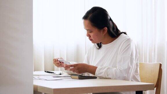 家庭财务规划与管理年轻的亚洲妇女在家里计算家庭财务账单
