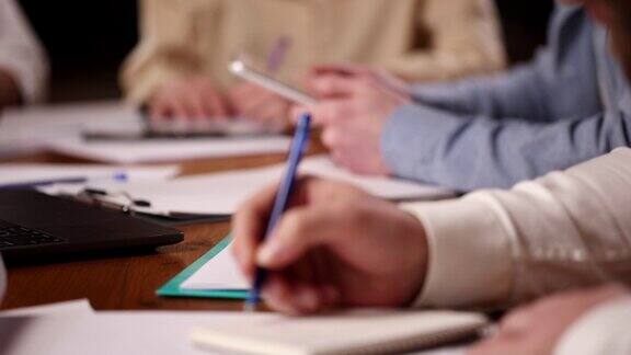 员工的手和工作台的特写同事在商务会议、会议上做笔记和工作