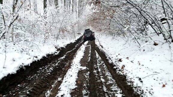 追踪越野车行驶在冰冻森林的泥泞小路上