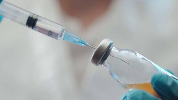 特写医生手持装有透明溶液的注射器并将黄色物质注入安瓿中疫苗开发过程医学实验室的实验研究抗冠状病毒感染的潜在疫苗