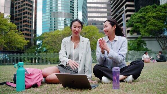 年轻成年亚洲女学生在校园里用笔记本电脑一起学习和学习