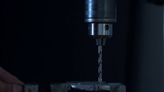 一个工业钻孔进入金属部分的特写镜头