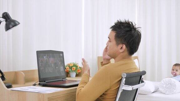 亚洲男性在家工作通过视频会议在卧室里用笔记本电脑交流