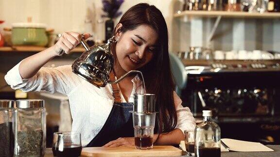 亚洲职业女咖啡师作为店主在自助餐厅的柜台酒吧为拿铁咖啡倒牛奶女服务员正在煮咖啡人们的生活方式和职业工作4k的片段
