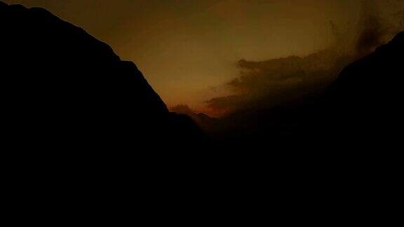 日落时云倾泻过山口