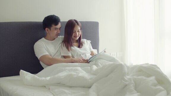 亚洲丈夫和怀孕的妻子会在卧室里一起读书给孩子听