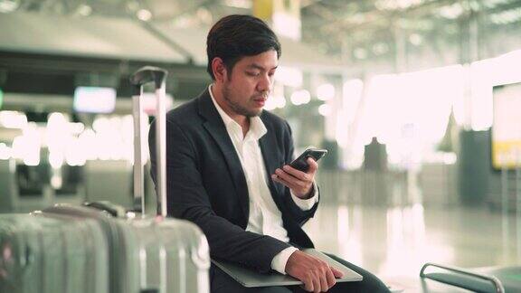 商人在机场等候时使用手机