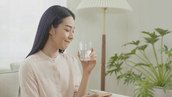 美丽的亚洲女人在家里喝水保健和饮食