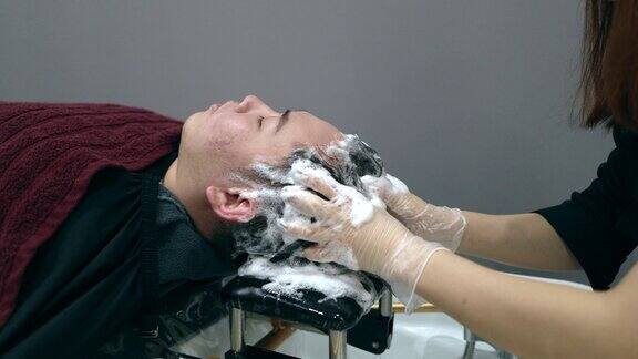 理发师正在给一个男人洗头发和按摩