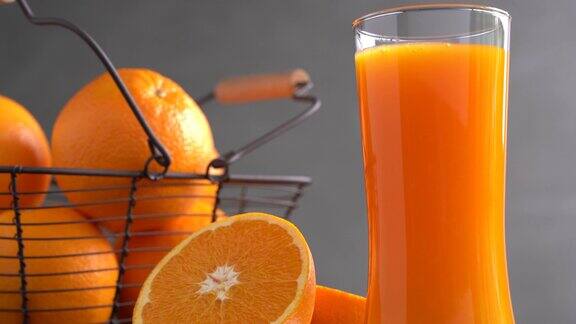 新鲜的橙汁在高脚杯和一篮橙子
