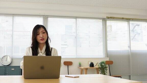 一个轻松的日本女人在小办公室里远程工作