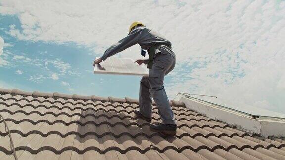 男工人在屋顶上拿着太阳能板