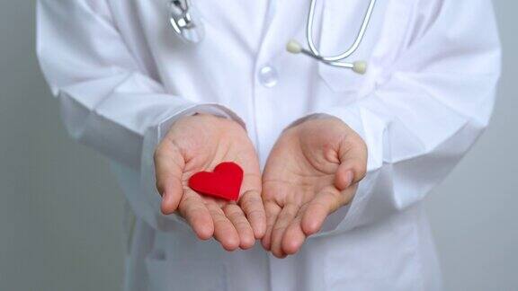 医院里医生手握红色的心形爱捐赠者世界心脏日世界卫生日企业社会责任捐赠和保险概念