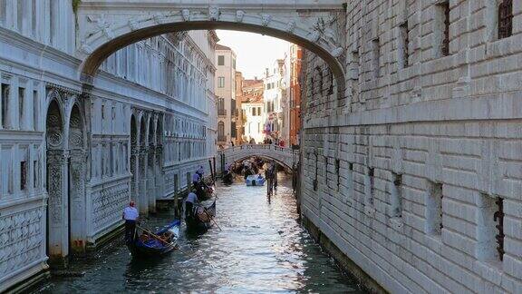 船夫载着乘客穿过威尼斯狭窄的运河
