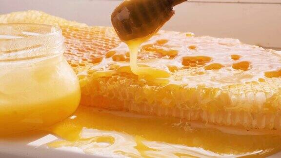 蜂蜜从蜜匙滴到蜂房架上天然液体蜂蜜从滴管上滴到蜂蜡上