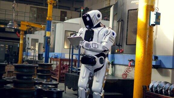 仿人机器人正在工厂里用平板电脑工作
