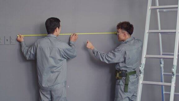 一对建筑工人测量墙
