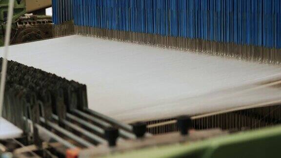 织布机特写镜头纺织厂正在工作的工业织布机编织